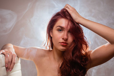 Portrait of beautiful young woman with hand in hair