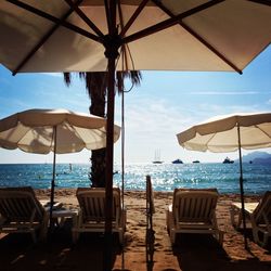 Chairs and parasols on beach against sky