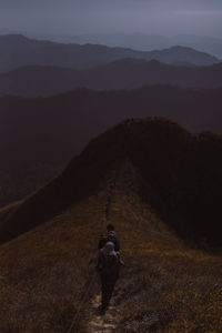 Rear view of man on mountain against sky