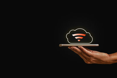 Man using smart phone against black background