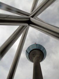 Low angle view of communications tower against cloudy sky