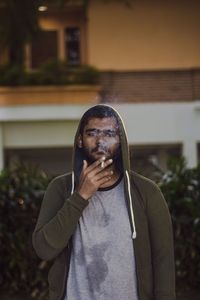 Portrait of man standing against built structure