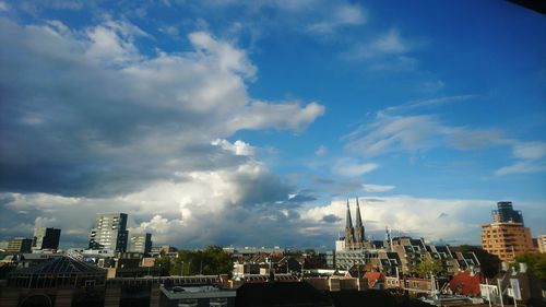 View of cityscape against cloudy sky