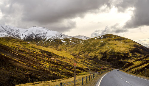 Street by mountains against sky