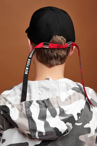 Rear view portrait of boy relaxing against white background