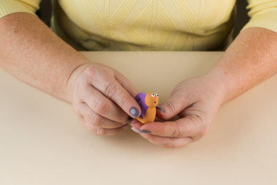 A snail made of polymer clay. step-by-step instruction. step 11 attach the head.