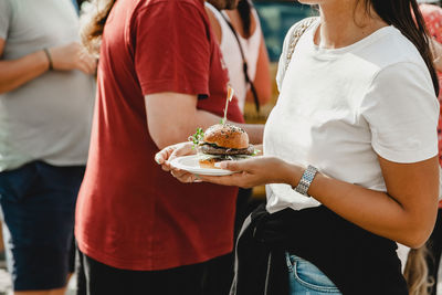 Woman holds in his hand burgers at a burger feast. dinner hamburger food feast party. big burger in