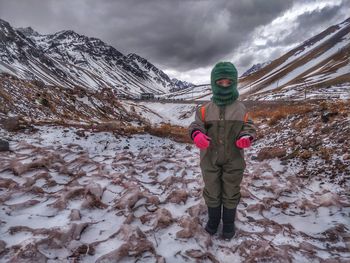 Man standing on snow covered mountain against sky