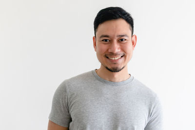 Portrait of smiling young man against white background