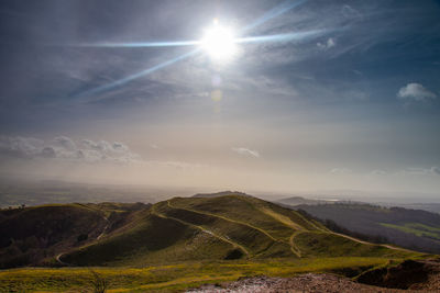 Scenic view of landscape against bright sun