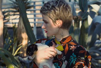 Close up attractive woman holding small puppy in garden portrait picture