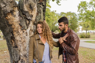 Couple arguing by tree at park