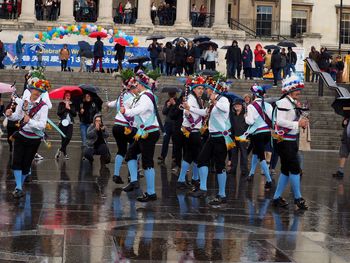 People walking on wet street in city