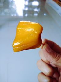Close-up of hand holding yellow ice cream
