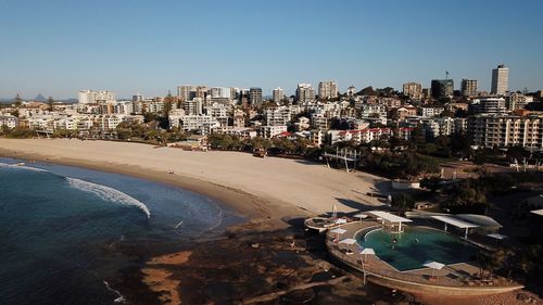 High angle view of buildings by sea against clear sky