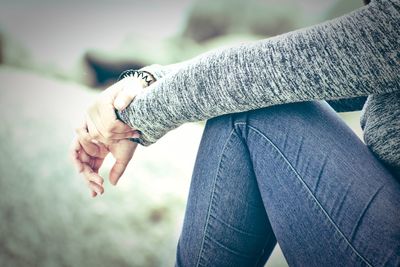 Midsection of woman sitting on field