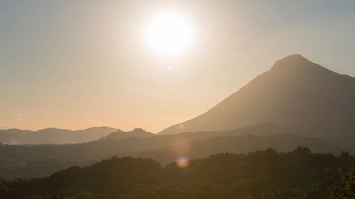 Scenic view of silhouette mountains against clear sky at sunset