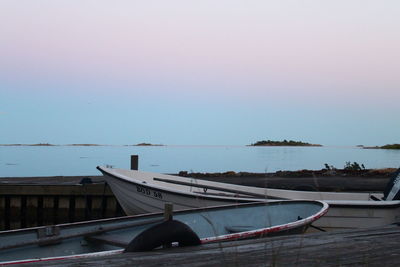 Boats moored in sea against clear sky