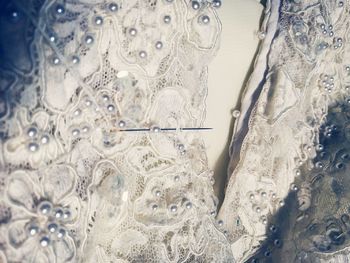 Close-up of needle on white dress