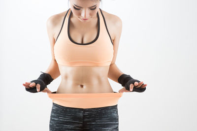 Midsection of woman standing against white background