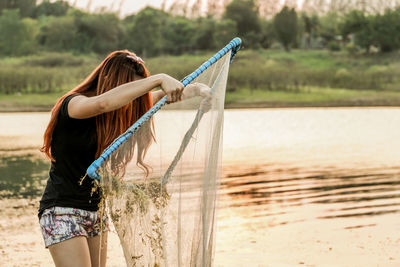 Woman with umbrella standing in water