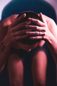 Close-up of woman covering face with hand