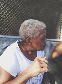 Senior woman looking away while sitting outdoors