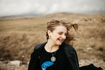 Portrait of a smiling young woman on field