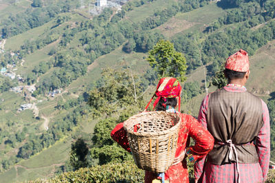 Rear view of man working on landscape against mountain