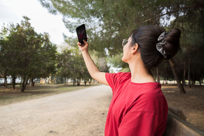 Full length of woman photographing through mobile phone