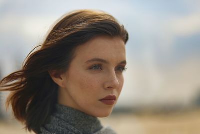 Close-up portrait of young woman looking away