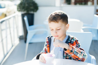 Boy eating ice cream at table