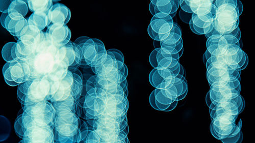 Close-up of illuminated lighting equipment against black background