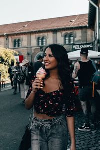 Full length of a woman drinking glass in city