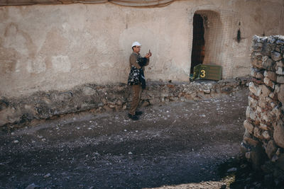 Full length of a man standing against wall