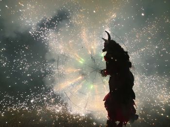 Firework display against sky at night