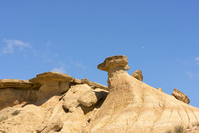 Low angle view of horse on rock formation against sky