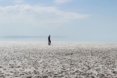 Man standing on beach against sky