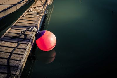 High angle view of buoy hanging on pier over lake