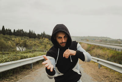 Portrait of young woman standing against sky