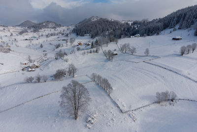 Scenic view of snow covered field against sky