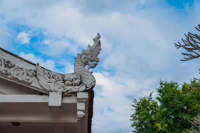 Low angle view of statue against building and sky