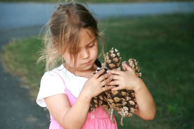 Close-up of girl holding fruit while standing outdoors