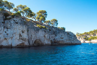 Scenic view of sea and rocks against clear sky