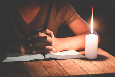 Close-up of hand holding book on table