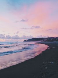 Scenic view of beach against dramatic sky