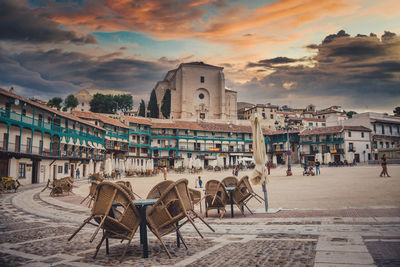 Chairs on table at beach against buildings in city