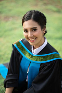 Portrait of smiling young woman wearing graduation gown