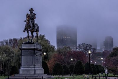 Statue in park with city in background
