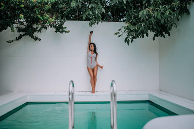 Full length of woman jumping in swimming pool